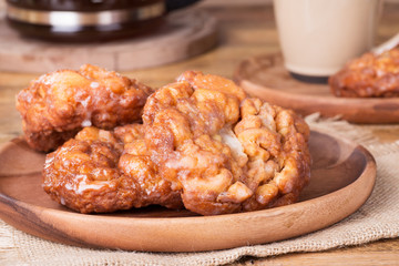 Closeup of Glazed Apple Fritters on a Wooden Plate