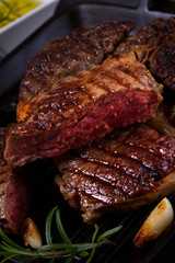 Grilled beef steak with spices close up on dark background