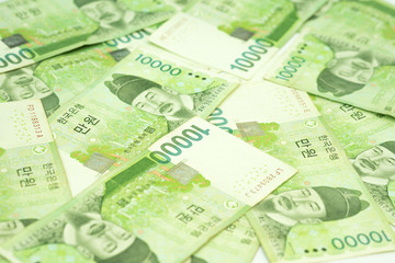 Pile of 10000 Korea won bills on table as money background.