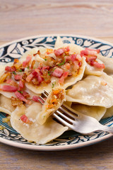 Dumplings, filled with cabbage and served with fried bacon and onion. Varenyky, vareniki, pierogi,...