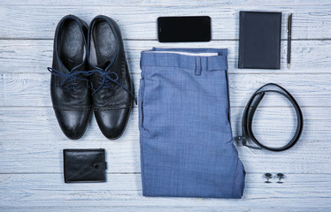 Set of stylish male clothes and accessories on wooden background