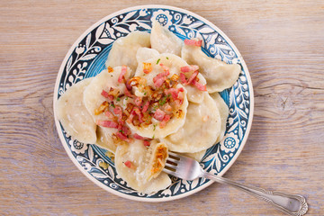 Dumplings, filled with cabbage and served with fried bacon and onion. Varenyky, vareniki, pierogi, pyrohy - popular dish in East Europe. View from above, top studio shot