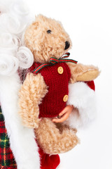 Santa Claus toy with teddy bear. Cropped image of Santa Claus doll holding adorable brown plush teddy bear toy. Merry Christmas and happy New Year.