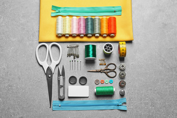 Set of tailoring tools and accessories on table, top view