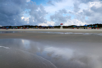 Vacation and travel background, lifestyle concept.Seascape with cloudy sky over colorful umbrellas and lifeguard tower at Huntington Beach State Park, south Myrtle Beach area, South Carolina, USA.
