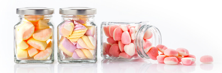 colorful candies in glass jars on white background - Web banner with food concept