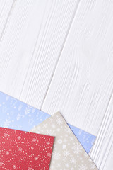 Colored patterned paper for New Year craft. Patterned sheets of paper for making New Year and Christmas ornaments on wooden background and copy space, top view.