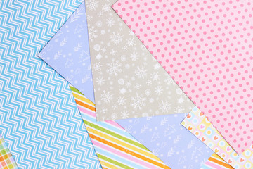 Fototapeta premium Paper background with winter design. Sheets of patterned paper for handmade New Year and Christmas ornaments, top view.