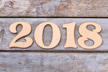 Cutout wooden number 2018 on old wooden background. Carved wooden digits forming number 2018 of the New Year on old rustic wooden table.