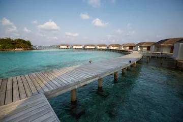 Fotobehang Water bungalows in hotel on Maldives. Villas on Indian ocean at luxury spa resort. © artiemedvedev