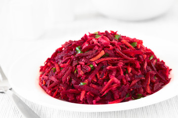 Raw grated beetroot, apple and carrot salad with parsley, photographed with natural light...