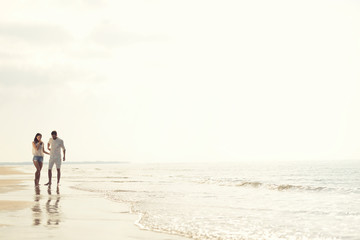 Fototapeta na wymiar Happy fun beach vacations couple walking together laughing having fun on travel destination.