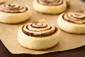 Homemade cocoa rolls or buns made of yeast dough and filled with sugar and cocoa powder,...