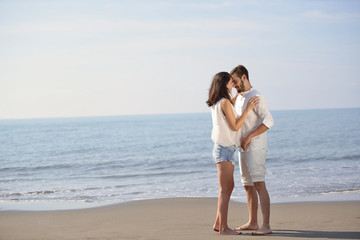 Romantic young couple on the beach kissing.