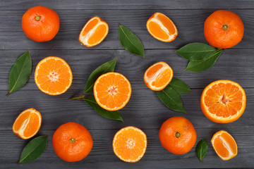 orange or tangerine with leaves on black wooden background. Flat lay, top view. Fruit composition