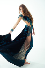 Girl posing in blue evening dress barefoot