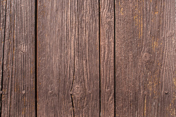 Old weathered brown painted wooden boards wall surface closeup as background
