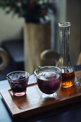 Berries tea with ice ball on wood background