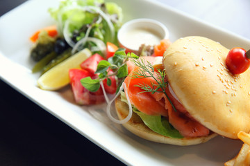 Smoked salmon Bagel with vegetables on wood background