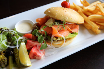Smoked salmon Bagel with vegetables on wood background