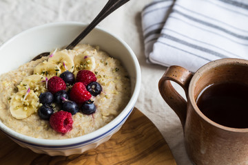 Porridge bowl with fruit and tea