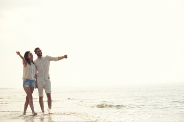 Happy fun beach vacations couple walking together laughing having fun on travel destination.