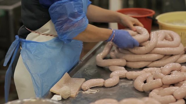 Workers of the meat-packing plant produce sausages