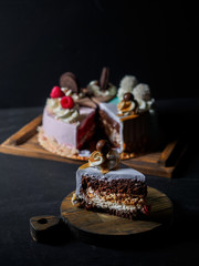 Set of pieces cakes on black background