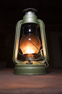 lit the old kerosene lamp standing on the table in crimson lights dim light a dark room
