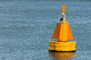 A yellow buoy floating on the water surface