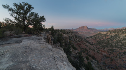The eastern rim of Wire Mesa in Southern Utah at dusk with a view of West Temple and Mt. Kinesava in the distance.