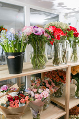 different varieties. Fresh spring flowers in refrigerator for flowers in flower shop. Bouquets on shelf, florist business.
