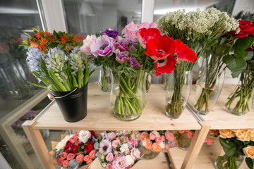 different varieties. Fresh spring flowers in refrigerator for flowers in flower shop. Bouquets on shelf, florist business.