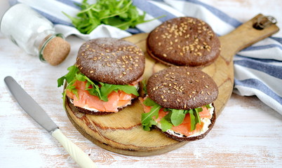 Smoked Salmon Sandwich with Cream Fresh and Arugula on Cutting Board