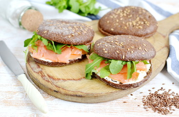 Smoked Salmon Sandwich with Cream Fresh and Arugula on Cutting Board