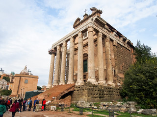 Fototapeta premium Tourists surrounding the Temple of Antoninus and Faustina in the Roman Forum in Rome Italy.
