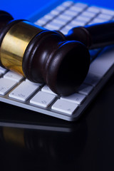 Obraz na płótnie Canvas Wooden law gawel close up on computer keyboard, internet auction concept