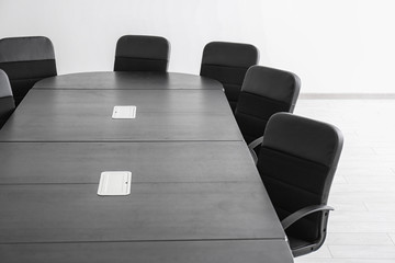 Modern office interior with table and black armchairs