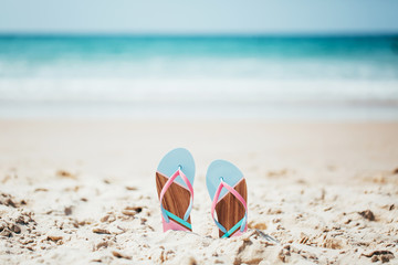 Trendy slippers on the sandy beach.