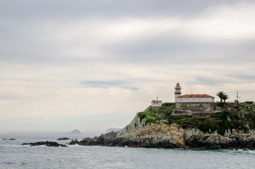 Fototapeta na wymiar With a turquoise water in front the Lighthouse of Cudillero in Asturias is one of the most beautiful places in the North of Spain