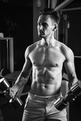 Handsome muscular man working out with dumbbells at gym. Bodybuilding, sport and fitness lifestyle....