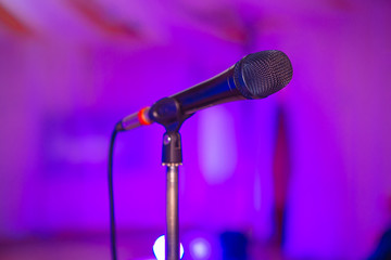 Microphone on the blurred background of the audio mixer of the musician.