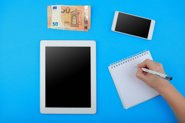 top view on the tablet, Notepad with pen, phone and Euro banknotes
