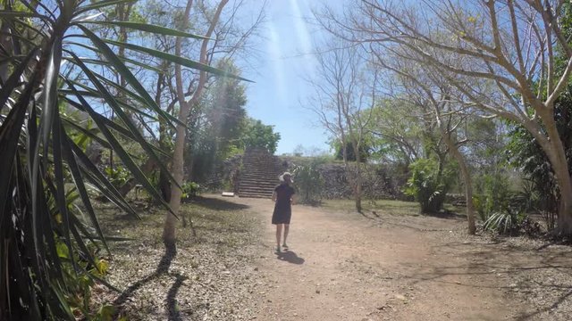 Gimbal shot of a tourist woman walking in Ek Balam Mayan Ruins