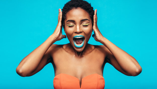 African woman with colorful makeup screaming