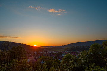 Beautiful landscape of sunrise over small town in forest mountains. Romania, Sighisoara - 2016.