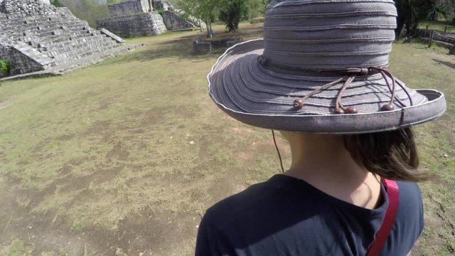 Gimbal shot of a woman walking in mayan ruins at ek balam