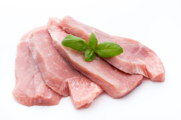 Fresh pork fillet with basil on a white background.
