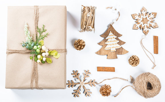 Classy Christmas gifts box presents in brown paper with toys and New Year decor on white. Merry christmas card background