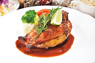 Half of appetizing roasted juicy chicken with lemon slices and  vegetables 